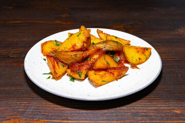 Delicious roasted potatoes served on a white plate in a rustic setting Savory vegetable pie served with fresh garnishes on a white plate