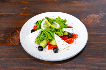 Fresh vegetable salad with feta cheese on a wooden table Savory vegetable pie served with fresh garnishes on a white plate