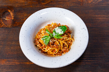 Savory spaghetti dish served on a wooden table at a cozy restaurant Savory vegetable pie served with fresh garnishes on a white plate