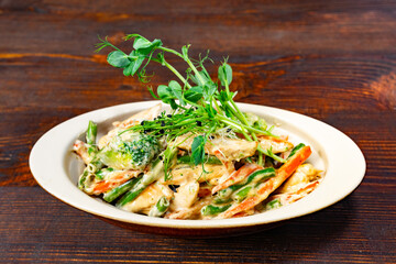 Delicious creamy pasta with vegetables served on wooden table Savory vegetable pie served with fresh garnishes on a white plate