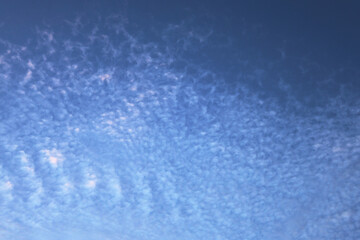 Blue sky with small piece of fluffy clouds