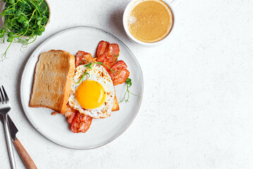 Breakfast sandwich  with fried egg, bacon and microgreens