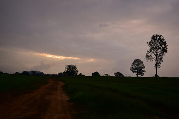 Dramatic sunset sky with clouds, picturesque field and scenic road, Russian landscape. Sky and clouds
