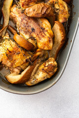 Baked chicken with pears and thyme, oval dish with baked chicken parts