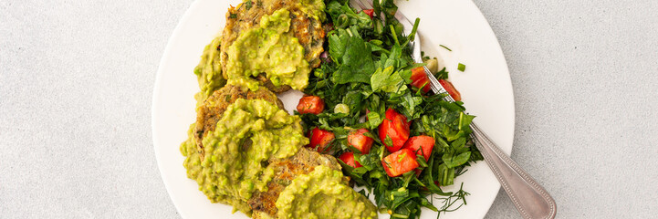 This nutritious breakfast features savory zucchini pancakes with green pea pesto, paired with a mixed salad of garden-fresh vegetables and herbs for a wholesome morning meal, banner