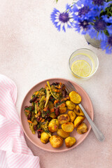 Stewed potatoes with stewed vegetables, broccoli and beans with carrots and herbs, a served table with food and a vase of flowers, a delicious hearty lunch or dinner