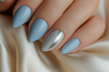 A close-up of pale blue nails with a minimalist silver stripe on a smooth cream backdrop