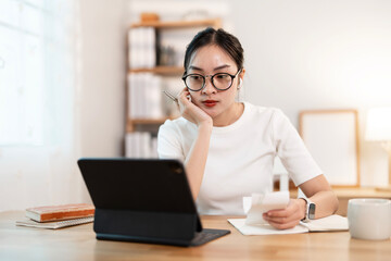 Young woman using computer working online at home.