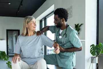 Obraz premium Doctor helping patient with physical therapy for injured shoulder recovery and pain relief