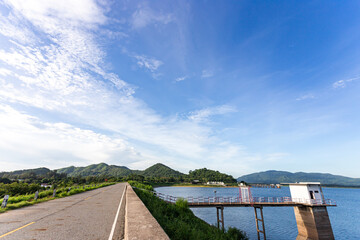 long road through a quiet reservoir in the countryside with mountains and beautiful nature