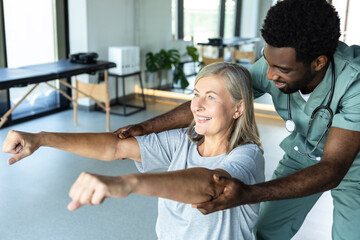 Man chiropractor assisting adult woman patient with pain relief and recovery through rehabilitation