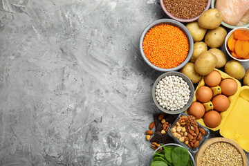 Diet plan for anemia. Different products rich in iron on grey table, flat lay. Space for text