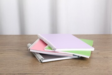 Doing homework. Stack of notebooks on wooden desk. Space for text