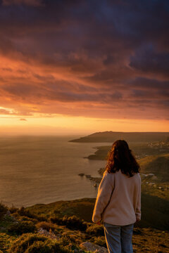 Woman looking at Mani Peninsula with coastal villages at sunset