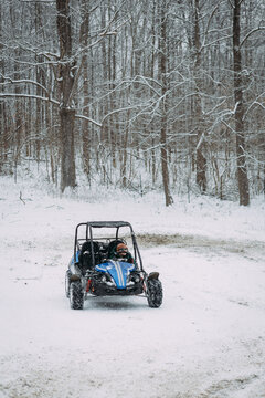 Preteen boy driving go kart in snowy wintry scene
