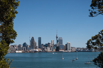 Obraz premium View onto skyline of Auckland as seen from Devonport on a summer day with perfect blue sky (Auckland, North Island, New Zealand)