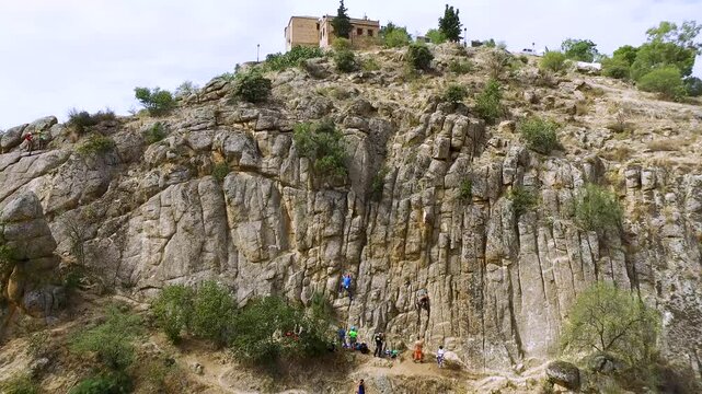 Imagen a&eacute;rea de grupo de personas practicando escalada en una pared de roca