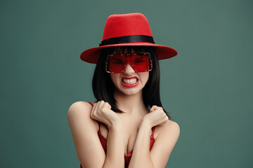 Red hat, sunglasses, woman, funny expression a woman wearing a red hat and sunglasses stands with...