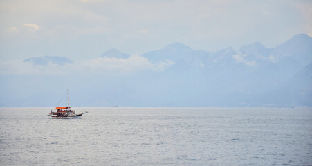 Obraz premium Anatolian mountains and yacht, view from the sea. Antalya, Turkey.
