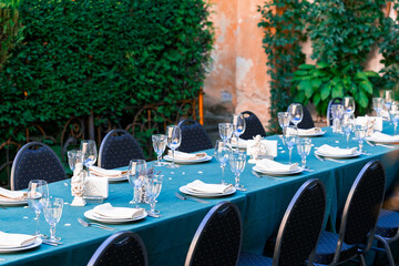 cutlery dishes on a served table vintage yard spring season outdoor environment with green bush plant