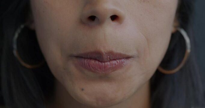 Close-up of female mouth grimacing while nervous young woman pursing lips. Negative emotion and face expressing concept.