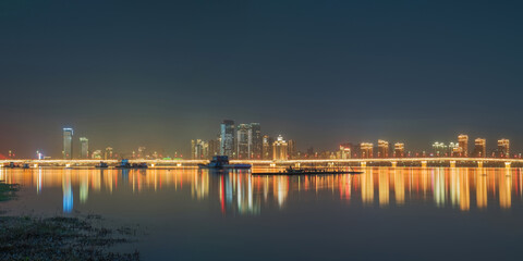 Naklejka premium The urban skyline, hero bridge, and night view of Ganjiang River in Nanchang City, Jiangxi Province, China on April 1, 2024