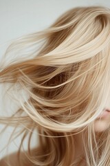 A close-up photograph highlighting flowing blonde hair in motion, with soft textures and delicate strands visible, providing an aesthetic sense of movement and beauty.