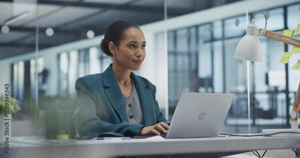Poster portrait of a beautiful african manager reviewing sales reports on laptop computer. she analyzes dat