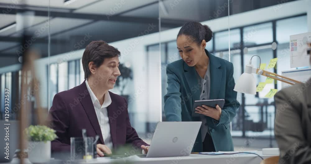 Aufkleber young female manager talking with experienced male colleague while using laptop and tablet computers