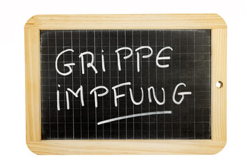 Obraz premium die Worte Grippe impfung in deutscher Sprache auf einer Tafel geschrieben