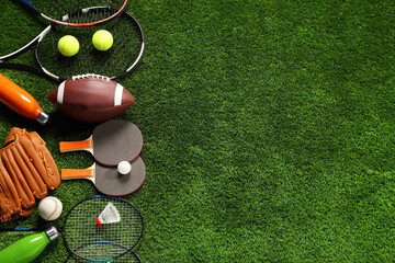 Different sports equipment on artificial grass, flat lay. Space for text