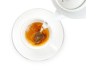 Pouring hot water into cup with tea bag on white background, top view