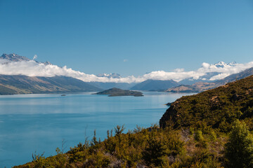 Scenic countryside with Lake Wakatipu as spotted en route to the small village of Glenorchy on a perfect summer day with some clouds (South Island, New Zealand)