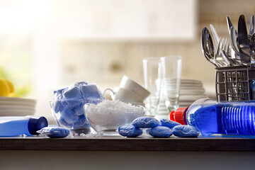 Automatic dishwasher cleaning products with tableware in the kitchen