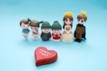 Figure toys happy family concept with mini home. Happiness, protection and children with parents relaxing together with mortgage or house insurance