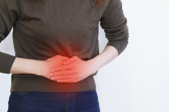 お腹を抑える女性　腹痛