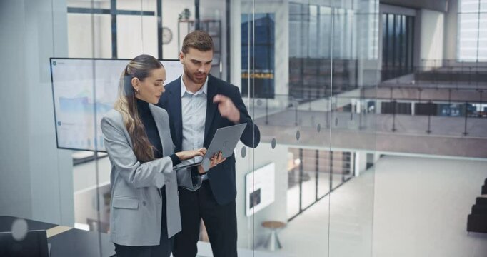 Young Coworkers Planning Next Business Steps in a Team Meeting, Using a Laptop Computer to Schedule Tasks and Assign Responsibilities. Caucasian Male and Female Using a Project Management Online Tool