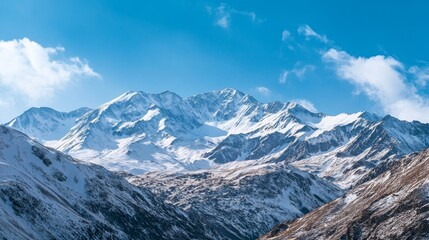 Fototapeta premium A panoramic view of a rugged mountain range with snow-capped peaks under a clear blue sky, Mountain landscape scene, Majestic natural style