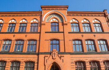 Front facade of a red brick building in Torun, Poland