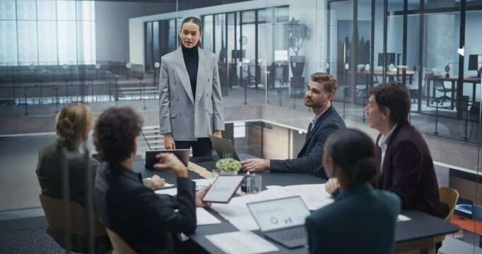 Female Analyst Making a Presentation to a Board of Executives in a Corporate Meeting Room. Managers, Lawyers, Investors and Partners Listening to the Team Leader, Inspecting Company Growth Metrics
