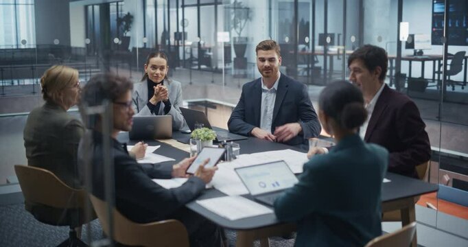 Specialists Working in a Modern Glass Office, Utilizing Laptop Computers and Paper Documents For the Meeting. They Collaborate on a Project, Exchanging Information and Leveraging Diverse Expertise