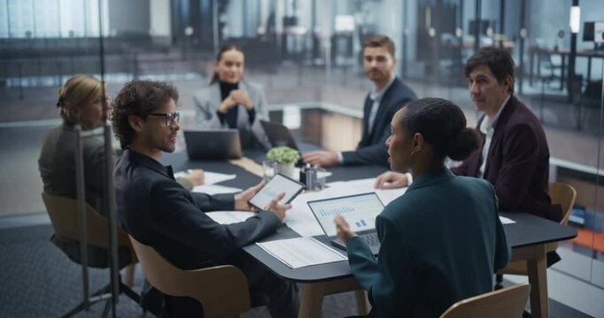 Diverse Business Team Engaged in Lively Discussion During a Brainstorming Session in a Glass Conference Room. Creative Ideas Flow as Male and Female Team Members Share Their Insights and Perspectives - Powered by Adobe
