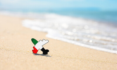 Obraz premium Vacation on the coast of the United Arab Emirates. Airplane in the colors of the flag of the United Arab Emirates on the seashore