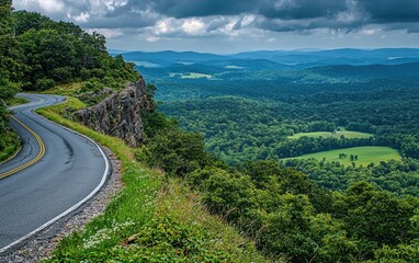 Fototapeta premium A curvy road climbing a mountain ridge with breathtaking views of valleys and greenery
