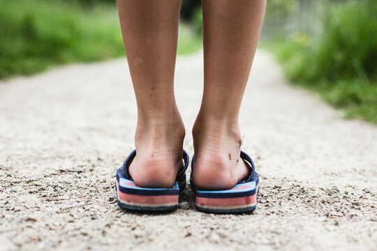 Rear view low close-up of a boy's feet wearing flip flops