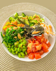 Top view of a colorful salmon poke bowl with fresh vegetables and rice