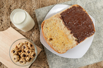 Bread with chocolate spread filling, milk and snack for breakfast	
