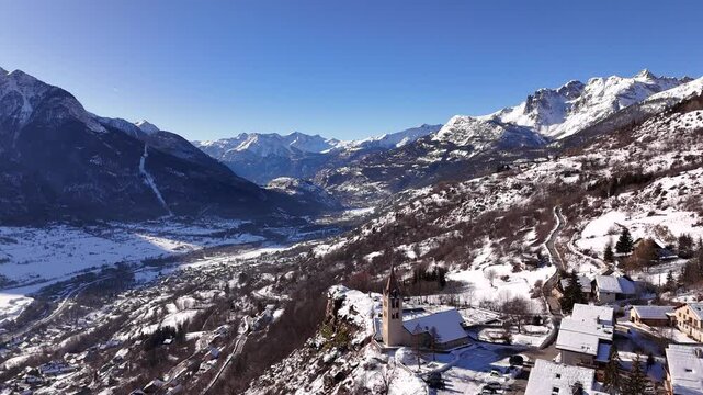 Majestic alpine mountain valley winter scene with clear blue sky and snowcapped peaks