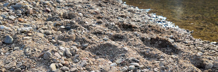 Close-up of a rocky lakeside shoreline with clear water, capturing the essence of natural serenity and tranquility