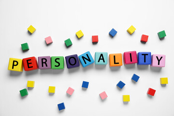 Word Personality made of colorful cubes with letters on white background, top view